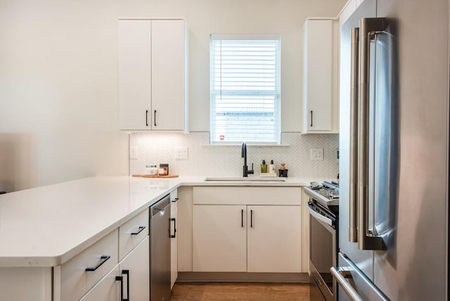 417 E College Ave Unit 102, Decatur, GA 30030 - kitchen with stainless steel appliances, a sink, a peninsula, backsplash, and light countertops
