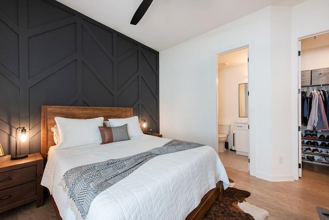 417 E College Ave Unit 102, Decatur, GA 30030 - bedroom featuring a spacious closet, a decorative wall, a closet, connected bathroom, and baseboards