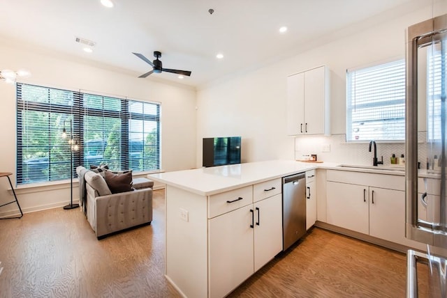 417 E College Ave Unit 102, Decatur, GA 30030 - kitchen with stainless steel dishwasher, a sink, light wood-style flooring, a peninsula, and healthy amount of natural light