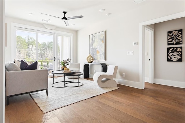 living room with wood finished floors, baseboards, and a ceiling fan