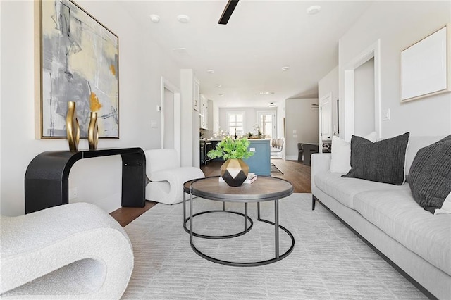 living area featuring light wood-type flooring and a ceiling fan