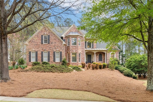 traditional-style house featuring a porch and brick siding
