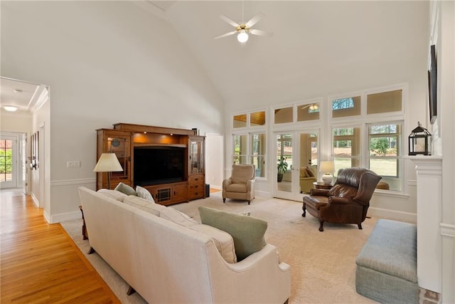 living room featuring baseboards, a ceiling fan, high vaulted ceiling, and french doors