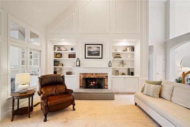 living area featuring built in features, a brick fireplace, high vaulted ceiling, and carpet floors