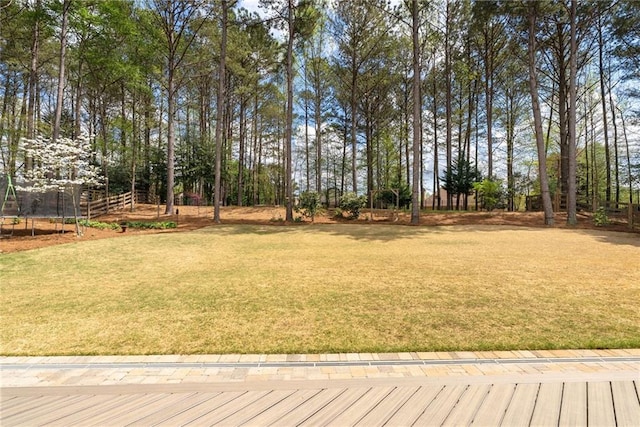 view of yard featuring fence and a trampoline