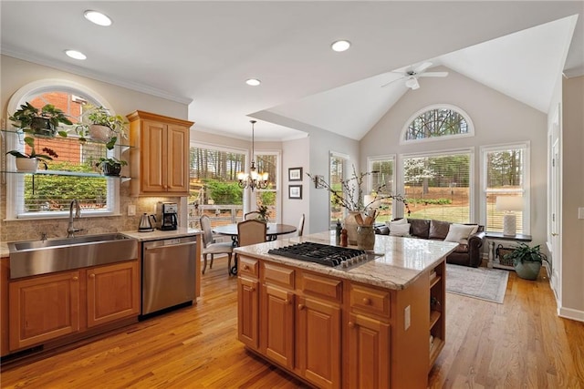 kitchen with decorative backsplash, a sink, ceiling fan with notable chandelier, light wood finished floors, and stainless steel appliances