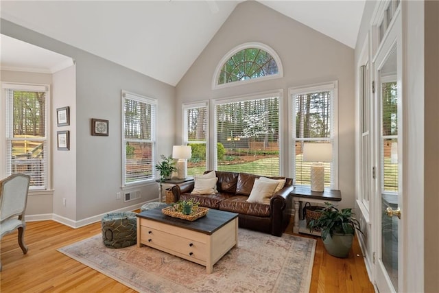 sunroom / solarium featuring visible vents, wood finished floors, and a healthy amount of sunlight