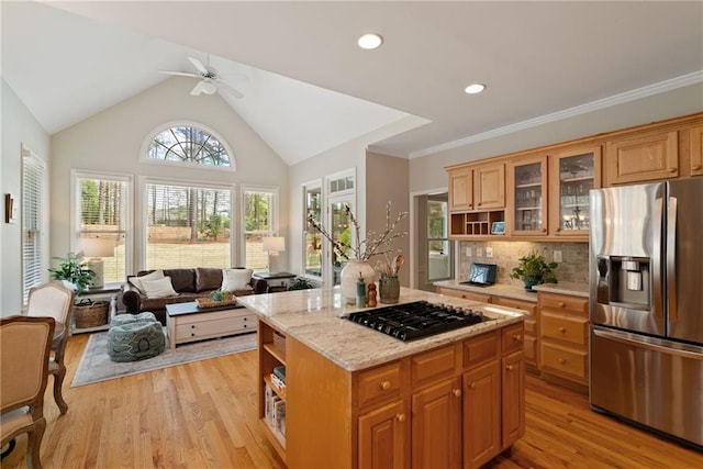 kitchen featuring ceiling fan, open shelves, gas stovetop, light wood finished floors, and stainless steel fridge