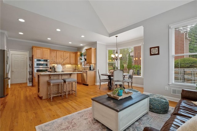 living area with ornamental molding, vaulted ceiling, recessed lighting, and a chandelier