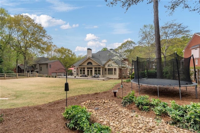 view of yard with fence, a patio area, and a trampoline