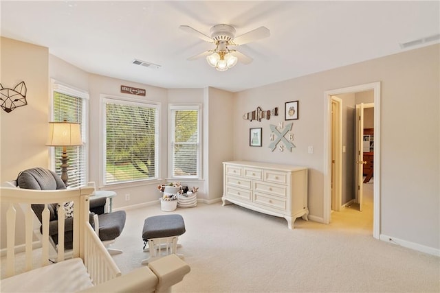 sitting room with visible vents, baseboards, ceiling fan, and light carpet