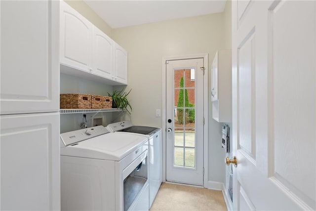 clothes washing area with cabinet space, light tile patterned floors, baseboards, and washer and clothes dryer