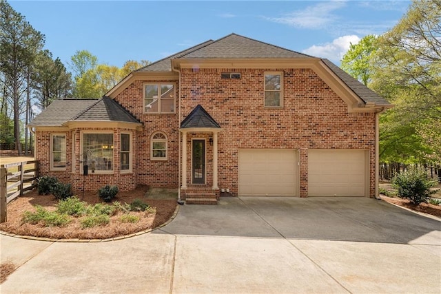traditional-style house featuring concrete driveway, brick siding, an attached garage, and fence