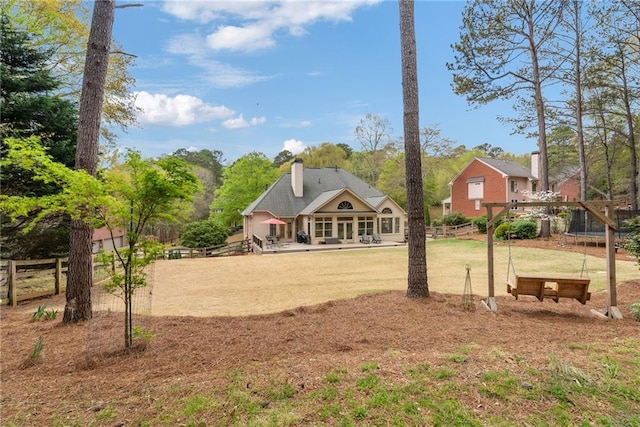 exterior space featuring fence, a chimney, and a yard