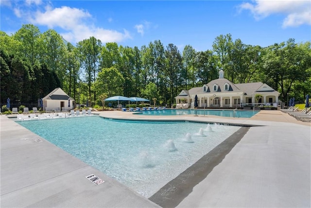 community pool with fence and a patio area