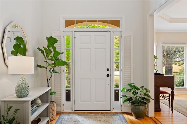 entrance foyer with crown molding and light wood finished floors