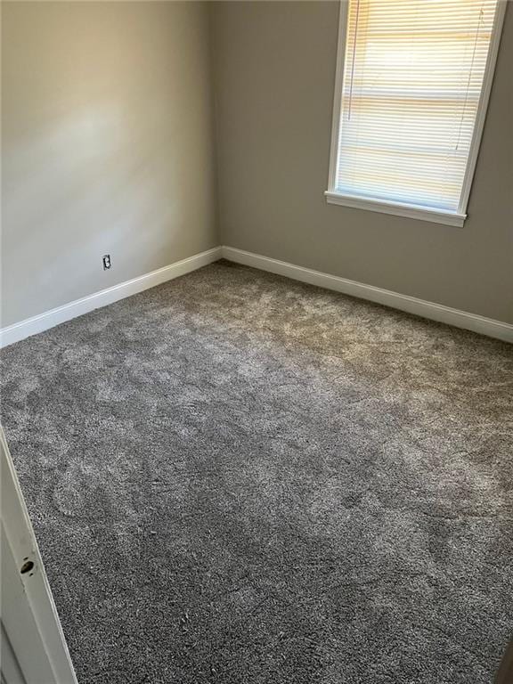 unfurnished room with dark carpet