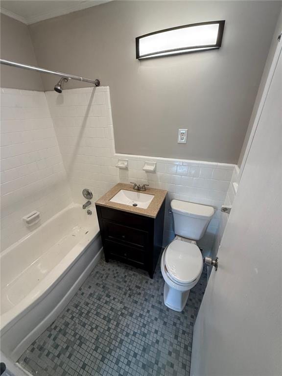 full bathroom with toilet, washtub / shower combination, tile walls, tile patterned floors, and vanity