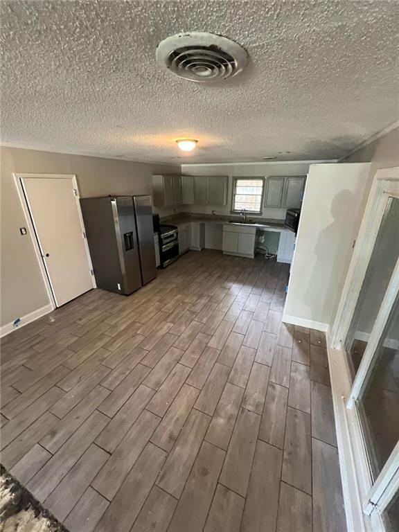 kitchen with sink, black / electric stove, and stainless steel fridge