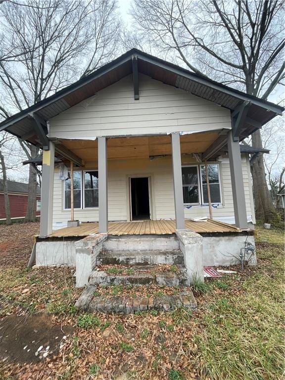 rear view of property featuring covered porch