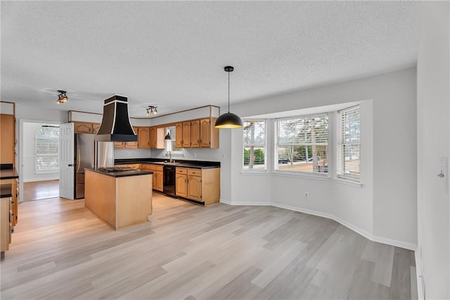 kitchen featuring a textured ceiling, a center island, black dishwasher, light hardwood / wood-style floors, and hanging light fixtures