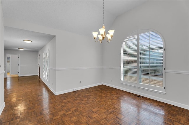 spare room featuring dark parquet floors, vaulted ceiling, and a notable chandelier