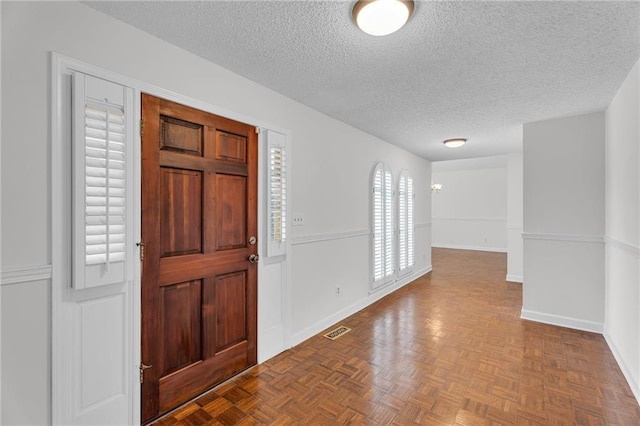 entrance foyer with a textured ceiling and parquet floors