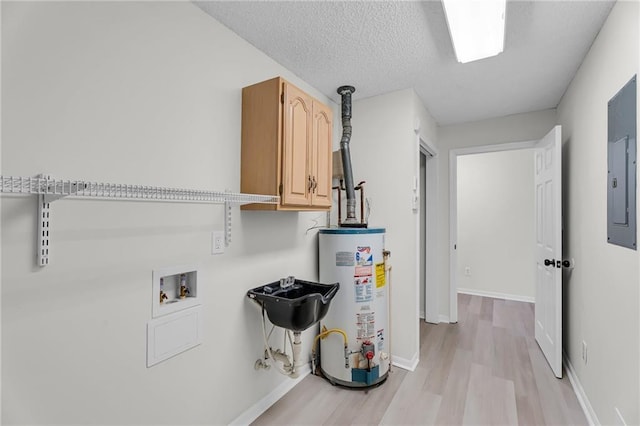 washroom with cabinets, gas water heater, washer hookup, light wood-type flooring, and a textured ceiling