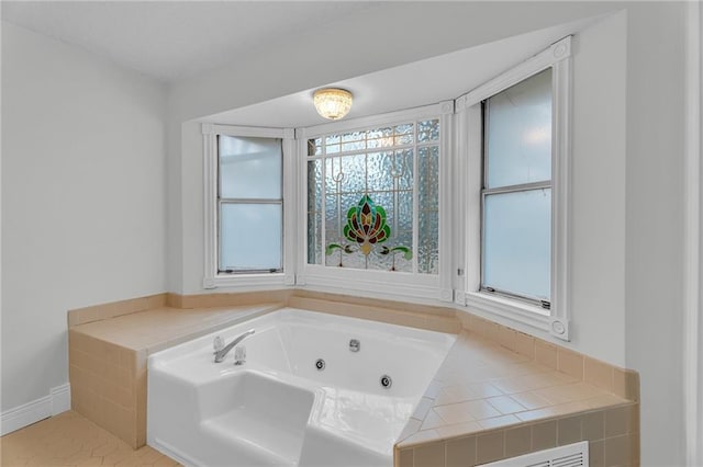 bathroom featuring tiled tub and tile patterned flooring