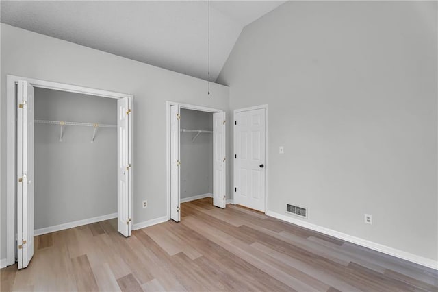 unfurnished bedroom with light hardwood / wood-style floors and vaulted ceiling