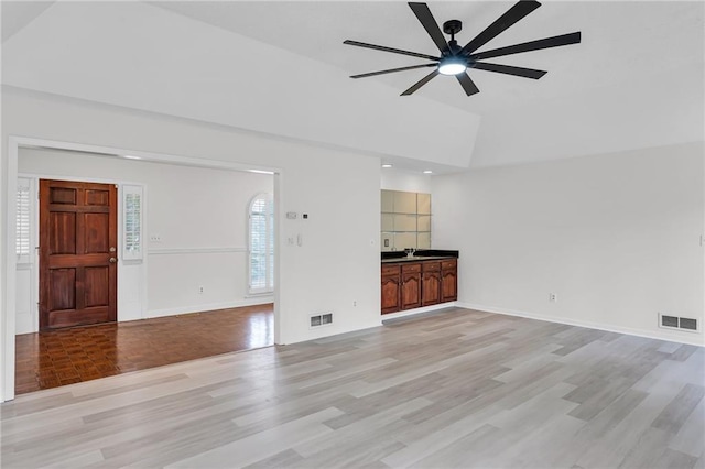 unfurnished living room with ceiling fan, light hardwood / wood-style flooring, and sink