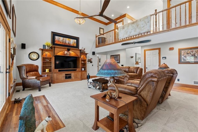 living room featuring recessed lighting, a high ceiling, wood finished floors, visible vents, and baseboards