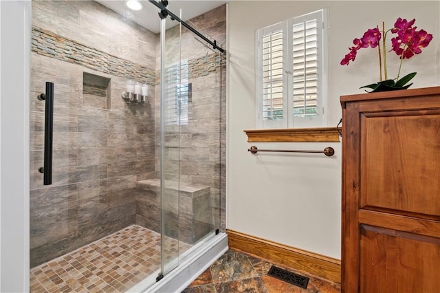 full bathroom with a stall shower, visible vents, and baseboards