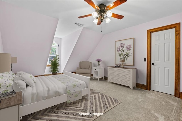 carpeted bedroom featuring lofted ceiling, visible vents, and a ceiling fan