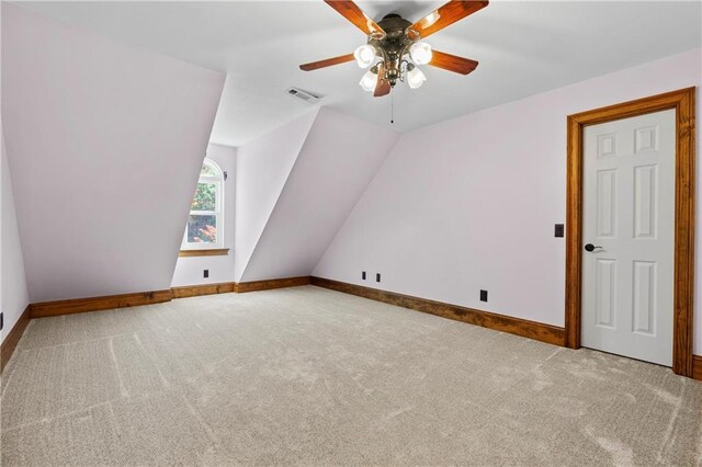 additional living space with carpet floors, lofted ceiling, visible vents, a ceiling fan, and baseboards