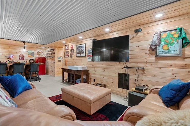 living room featuring concrete flooring, recessed lighting, and a bar