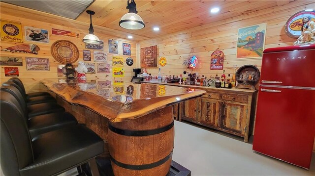 bar with pendant lighting, recessed lighting, freestanding refrigerator, wood ceiling, and a bar