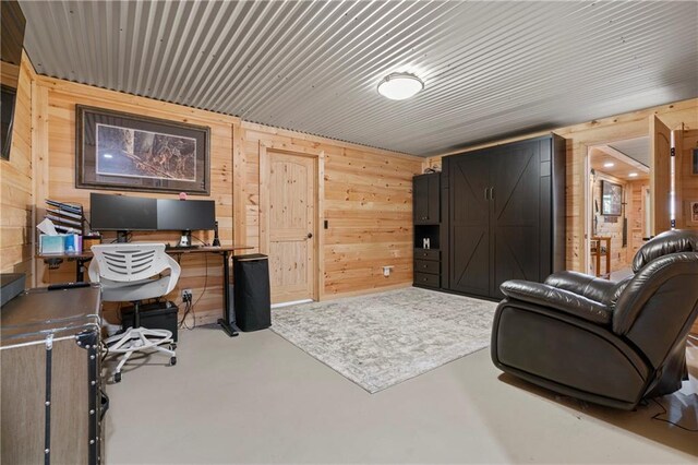 office area featuring concrete flooring and wood walls