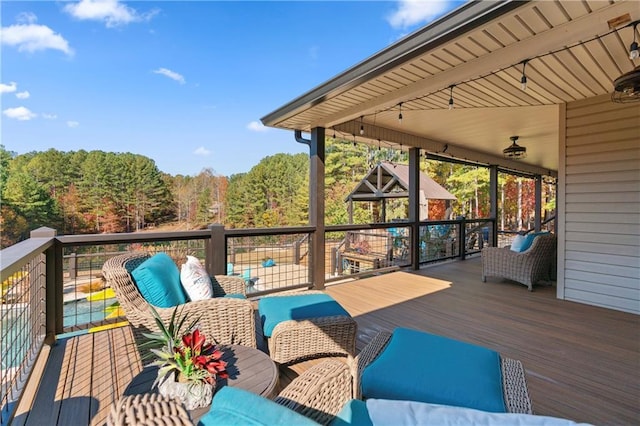 wooden terrace featuring an outdoor hangout area and a wooded view