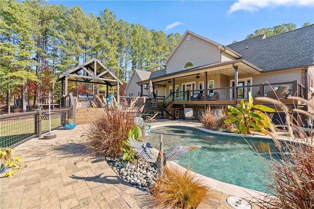 view of pool featuring fence, a wooden deck, and a hot tub