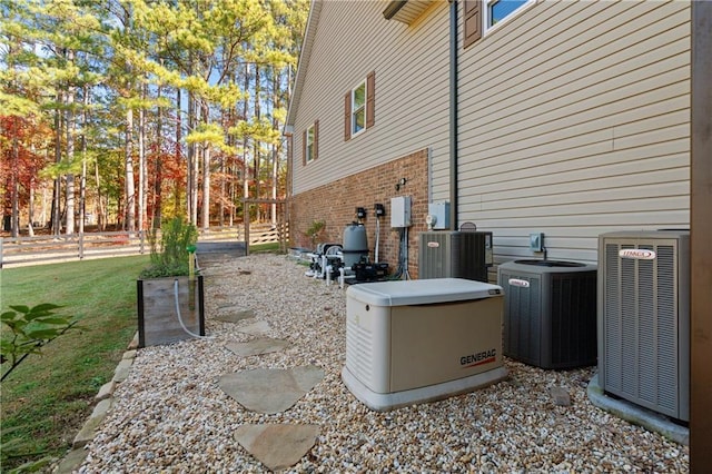 view of home's exterior featuring central AC unit, a lawn, and brick siding