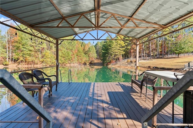 deck with a forest view, a dock, and a water view