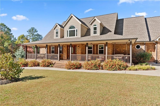 view of front of home with covered porch, brick siding, and a front lawn