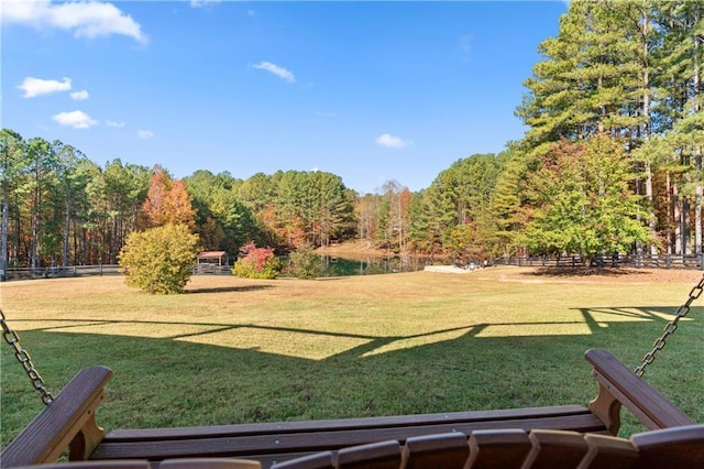 view of yard featuring a forest view and fence