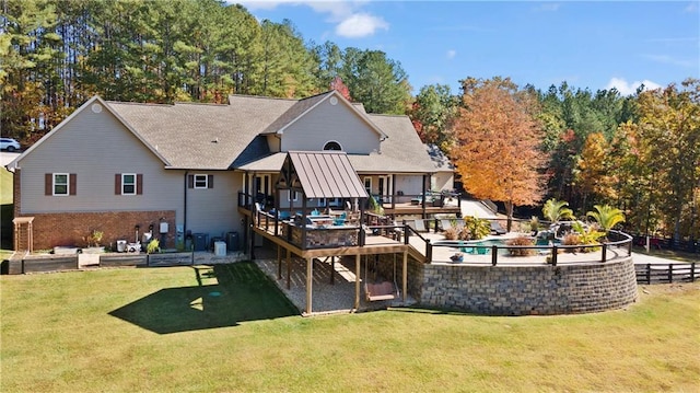 back of property with a yard, a deck, and fence