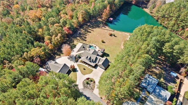 bird's eye view with a water view and a wooded view