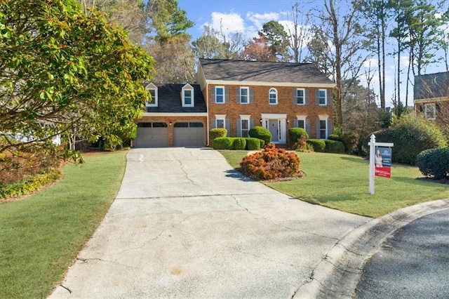 colonial home with a garage, concrete driveway, brick siding, and a front lawn