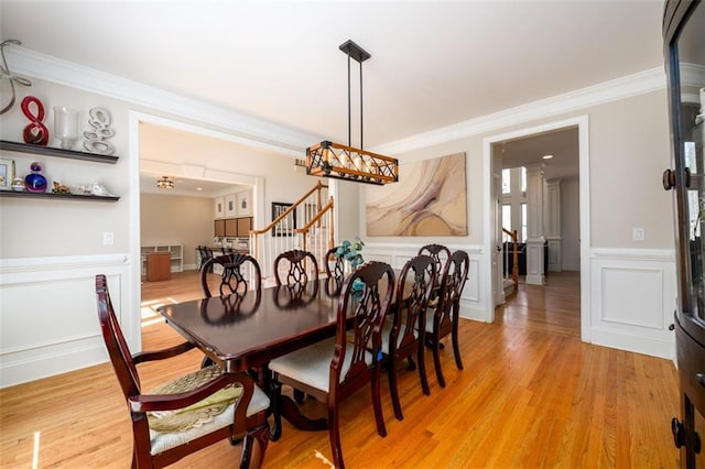 1105 River Laurel Dr, Suwanee, GA 30024 - dining room with crown molding, stairway, a wainscoted wall, light wood-type flooring, and a decorative wall