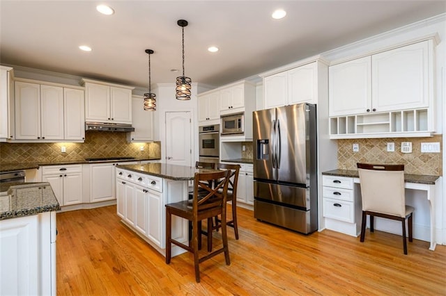 1105 River Laurel Dr, Suwanee, GA 30024 - kitchen with stainless steel appliances, under cabinet range hood, decorative backsplash, a kitchen bar, and recessed lighting
