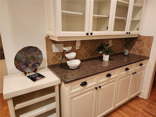 1105 River Laurel Dr, Suwanee, GA 30024 - kitchen with dark stone countertops, backsplash, glass insert cabinets, light wood finished floors, and white cabinets